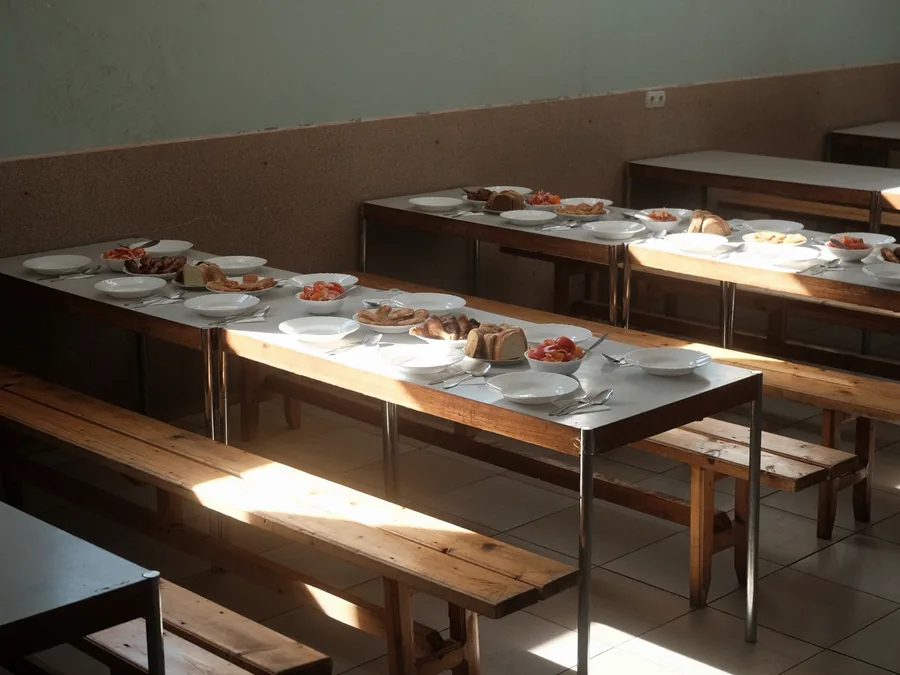 A plain dining hall, illustrating the mess arrangement for hostel residents