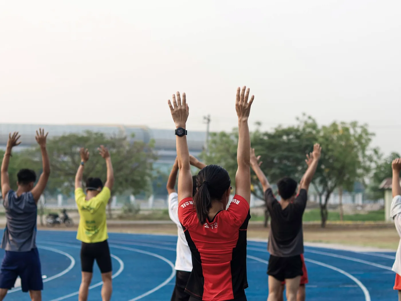 A group warming up on a running track before endurance work